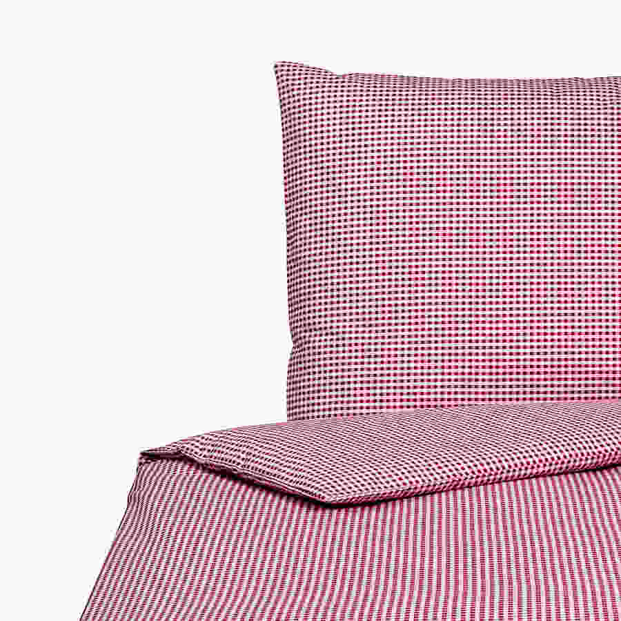 Detailblick auf rot-weiss-karierte Bettwäsche bestehend aus Kissen und Bettdecke